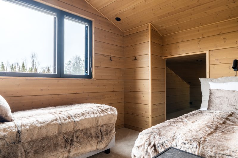 An upstairs bedroom with two single beds under the sloping ceiling.