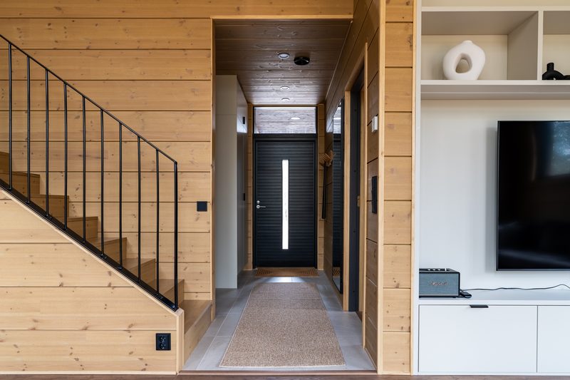 The entrance hall with the front door at the end, the staircase on one side and a coat area.