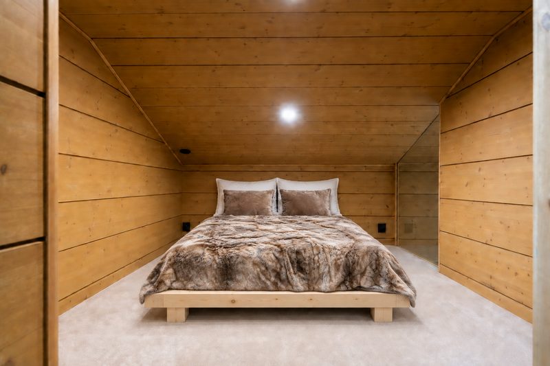 A double futon bed on the upper landing under the sloping timber ceiling.